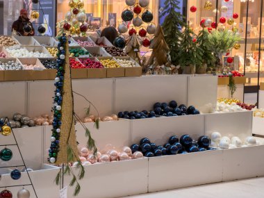 Geniş bir yelpazede pırıl pırıl Noel mücevherleri, minyatür ağaçlar ve küçük evler titizlikle perakende satışta sergileniyor, bayram dekoru sunuyor.