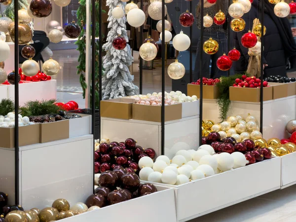 Perakende satış kutularındaki parlak kırmızı, beyaz, altın ve kahverengi Noel mücevherleri, hareketli tatil sezonu alışverişi için şenlikli dekorasyonlar.