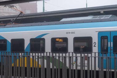 Poznan, Polonya - 30 Kasım 2025: Modern bir elektrikli yolcu treni Gdynia Glowna Szczecin Gl 'nin sergilendiği sisli bir istasyonda bekliyor.