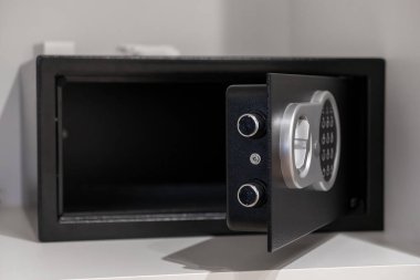 Modern dijital bir tuş takımının yer aldığı boş bir elektronik kasanın kapatılması, otel odalarında veya konut ortamlarında değerli eşyalar için güvenli bir depo sağlanması