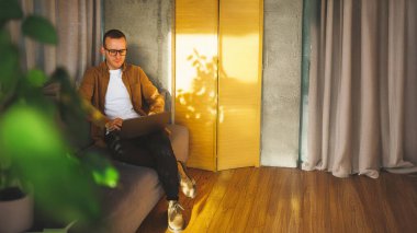 Genç yetişkin adam gündüzleri dinlenme odasında çalışıyor.