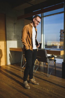 Gözlüklü genç girişimci iş başarısı için çok çalışıyor.