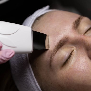 Bir güzellik uzmanıyla randevusu olan beyaz bir kadının ultrasonik temizliği.