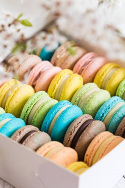 Kutuda bir sürü renkli badem kurabiyesi var. Mavi, yeşil, sarı, kahverengi renkli tatlılar.