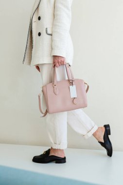 Bir kadının parlak pembe bir el çantası var. Yeni çantasıyla şık bir kız.