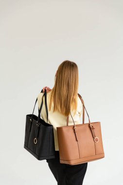 Bir mankenin elinde iki küçük kadın çantası. Modern moda bir el çantasının fotoğrafı. Ayrıntılı kadın toplantıları.