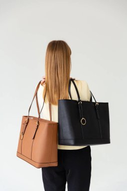 Bir mankenin elinde iki küçük kadın çantası. Modern moda bir el çantasının fotoğrafı. Ayrıntılı kadın toplantıları.