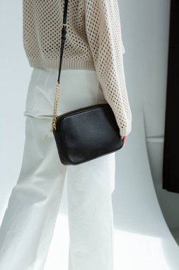 Siyah deri çanta, hafif bir ortamda minimalist tasarım.