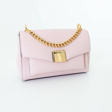 Beyaz arka planda açık pembe kadın çantası. Şık aksesuarlar ve giysiler.