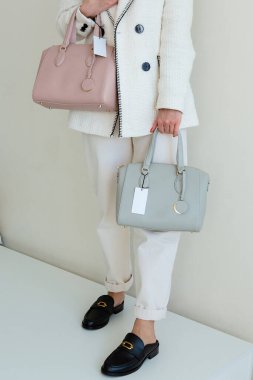 Pembe ve mavi çantalar yan yana. Mağazada iki kadın çantası var..