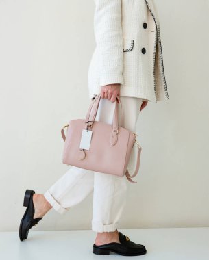 Bir kadının parlak pembe bir el çantası var. Yeni çantasıyla şık bir kız.