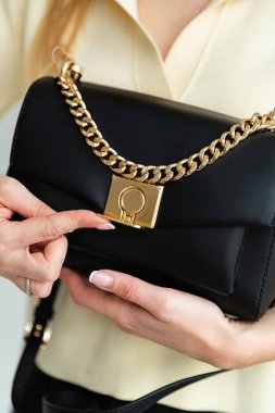 Genç bir kadının elindeki siyah çantayı aç. Çantanın dolabı hareket halinde.