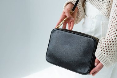 Siyah deri çanta, hafif bir ortamda minimalist tasarım.