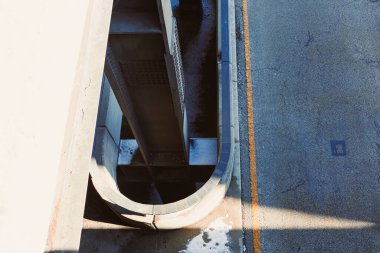 Beton asfalt ile kavisli bir yapının yol üzerinde durması gibi birleşir. Gölgeler gün ışığında kaldırımda desenler oluştururlar. Sahne şehir tasarımı ve şehir özelliklerini gösteriyor.