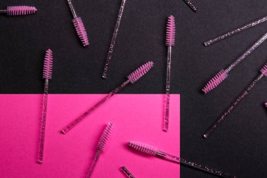 Brow fırçaları, yakın çevresindeki parlak pembe şekilli karanlık bir yüzeye dağılmış. Fırçaların temiz sapları ve pembe tüyleri var. Kurgu çeşitli açıları ve yerleri gösteriyor.