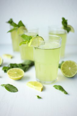 Taze ev yapımı limonata limon, limon ve nane bir bardak beyaz arka plan ve masaya döşeme malzemeleri