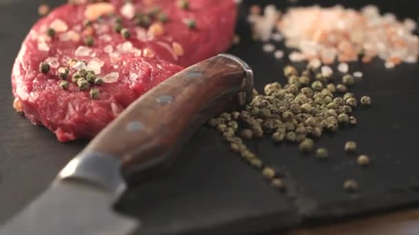 Filetto di carne di manzo crudo con granturco di pepe e timo e spezie diverse in bottiglie di vetro pronte da grigliare su tavola invecchiata a legna figurata sopra il tavolo 1920x1080 intro motion slow hidef hd — Video Stock