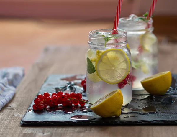 İki limonata limon ve nane ahşap masa arka plan üzerinde
