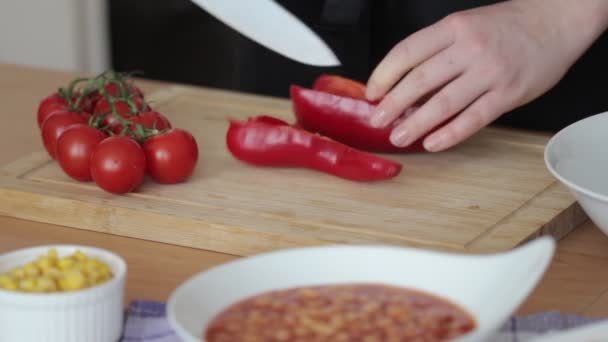Detalhe de mulheres mãos cortando pimentas vermelhas na cozinha . — Vídeo de Stock
