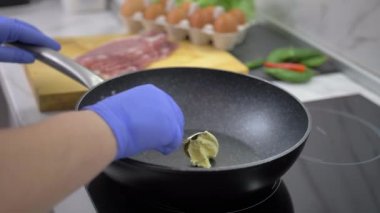 Kadın lastik eldivenle yemek pişiriyor.