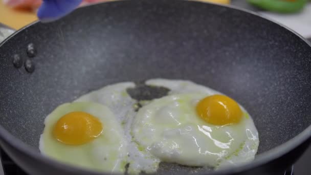 Huevos fritos en una sartén. Huevo roto cae en la sartén — Vídeo de stock