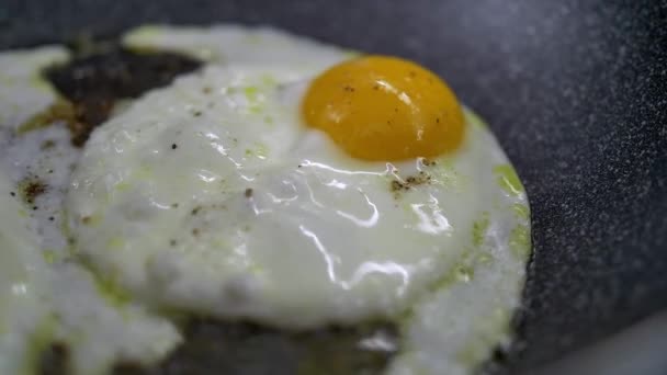 Смажені яйця на сковороді. Розбите яйце потрапляє в сковороду — стокове відео