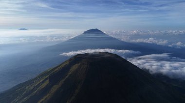 Hava manzaralı dağ zirvesi, bulut manzarası ve mavi gökyüzü. Hayranlık, macera ve sükuneti uyandırın. Seyahat, doğa, manzara ve ilham verici içerik için ideal. Gösterilen manzara güzelliği