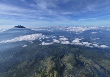 Panoramik manzara bulutların arasındaki dağ zirvesini ve manzarayı gözler önüne seriyor. Seyahet, doğa ve çevre için huzur verici, ilham verici bir manzara. Macera, keşif, özgürlük, kaçış