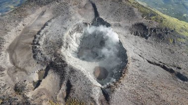 Hava görüntüsü volkanın kraterini ortaya çıkarıyor, buhar güçlü bir şekilde yükseliyor. Eğitim, seyahat, çevre keşfi veya araştırma potansiyeli sunan doğal bir mucize.