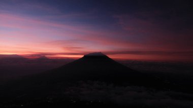 Şafağın dingin güzelliğini bu dağ görüntüsüyle yakala. Siluet renkli bir gökyüzü kontrastı. Seyahat, doğa, manzara ve barış için kullanılıyor. Huşu ve gezinti arzusu uyandırır.