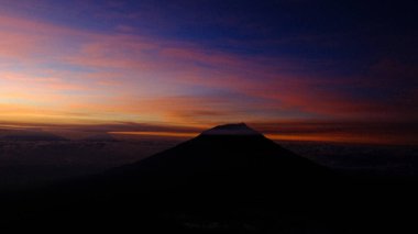 Dağın siluetini renkli bir gündoğumu gökyüzüne karşı yakala. Sahne huzur ve macerayı çağrıştırıyor. Reklam ve tasarımlarda seyahat, doğa ya da ilham kullanımı için mükemmel