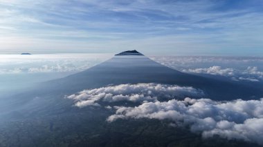 Bulutların üzerinde yükselen bir dağın dingin güzelliğini yakala. Seyahat, doğa ve macera teması için mükemmel. Bir merak, huzur ve keşif duygusunu çağrıştırıyor. İlham verecek bir manzara