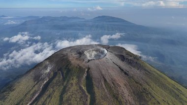 Krateriyle görkemli bir volkanın havadan görünüşü, sakin bir gökyüzünün altındaki manzara. Doğanın güzelliği ve jeolojik oluşumu. Seyahat, bilim, çevre ve macera için mükemmel