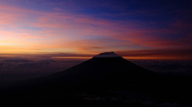 Gün batımında nefes kesici bir dağ görüntüsü yakalayın. Siluetli tepe, gökyüzüne karşı alev alev yanan renkler hayranlık uyandırıyor. Seyahat, doğa ya da ruhsal içerik için idealdir. 180