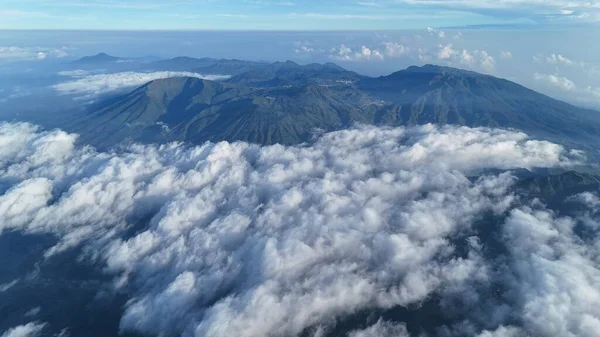 Dağ zirvelerinin havadan görünüşü bulutların örtüsünün üzerinde yükselir. Huzurlu manzara, doğanın güzelliği, seyahat için ideal, macera. Huşu, sükunet. Doğa aşıkları bayılıyor