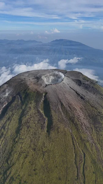 Nefes kesici hava manzarası görünür krateri olan görkemli bir volkan sergiliyor. Yeşil yamaçlar ve bulutlu gökyüzü sakin ama güçlü bir manzara yaratır. Macera ve jeoloji temaları için ideal