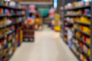 Raflarda canlı ürünlerle dolu bulanık bir süpermarket koridoru, perakende için ideal.