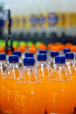Fabrika üretim hattındaki portakal suyu şişeleri dağıtılmaya hazır.