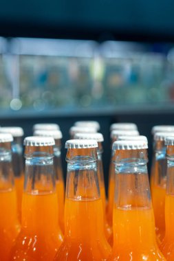 Raftaki cam şişelerdeki canlı portakallı gazoz reklam ve pazarlama kampanyalarında ticari kullanım için mükemmel.