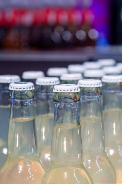 Serinlemek için masanın üzerinde beyaz kapaklı saf cam şişeler.