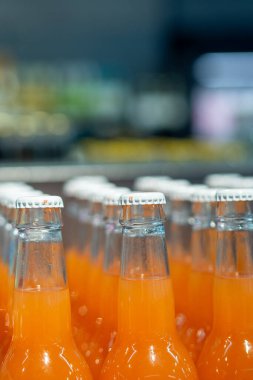 Portakallı soda şişeleri üretim hattında, ambalaj ve dağıtım için hazır.