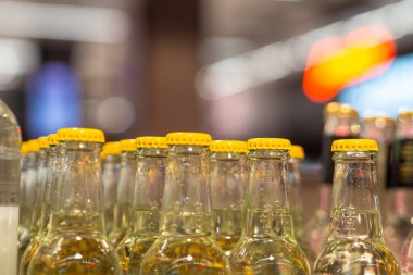 Masanın üzerinde doldurulmaya hazır sarı kapaklı saf cam şişeler.