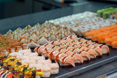 Çeşitli lezzet ve dokuların sergilendiği canlı bir suşi gösterisi. Restoran menüsü veya yemek reklamı için mükemmel.