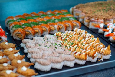 Canlı bir suşi sarması ve siyah tepside nigiri seçimi. Restoran ya da yemekle ilgili bir proje için mükemmel.