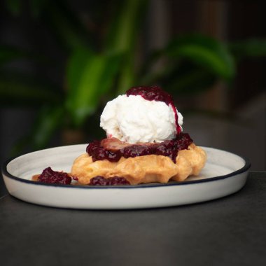 Krema ve böğürtlenli waffle, bir tabakta, yakın plan -