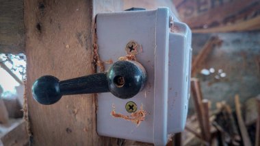 Atölye veya inşaat alanındaki ahşap kirişe bağlı tozlu endüstriyel dönüş anahtarı