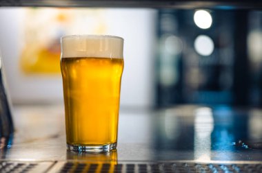 Barda ya da bar masasında soğuk bira bardağı. Çek Cumhuriyeti 'nin lezzetli taze sarı birası. Arka planda güzel bokeh olan karanlık bir bar..