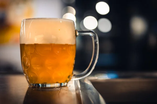 Barda ya da bar masasında soğuk bira bardağı. Çek Cumhuriyeti 'nin lezzetli taze sarı birası. Arka planda karanlık bir bar.