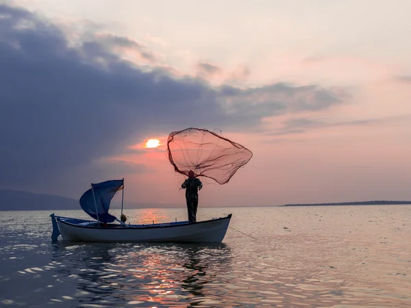 Pêcheur à travers le filet au lac sur l'heure du coucher du soleil — Photo