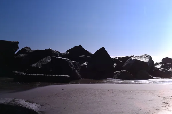 Lange blootstelling geschoten op het strand met mooie stenen en zee — Stockfoto